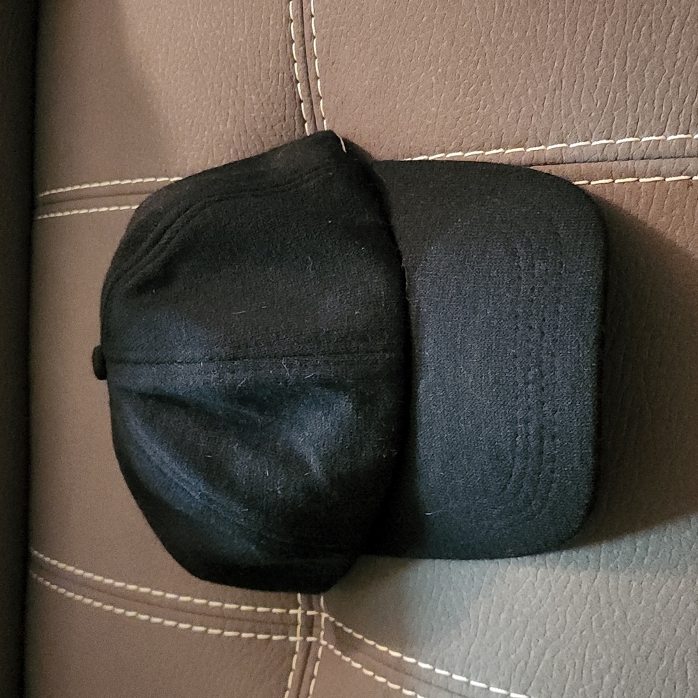Black hat with elastic in the back to allow for a high ponytail